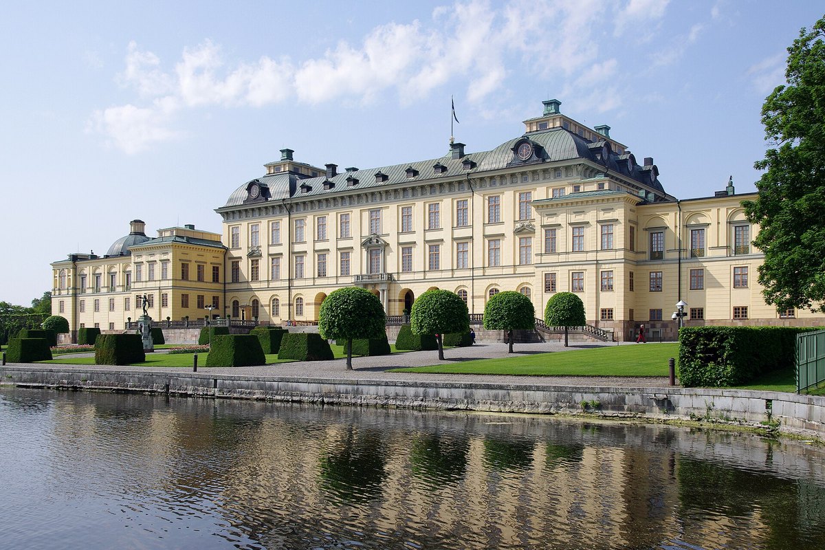 Drottningholm Palace and its clipped hedges reflected in the still water of Lake Mälaren