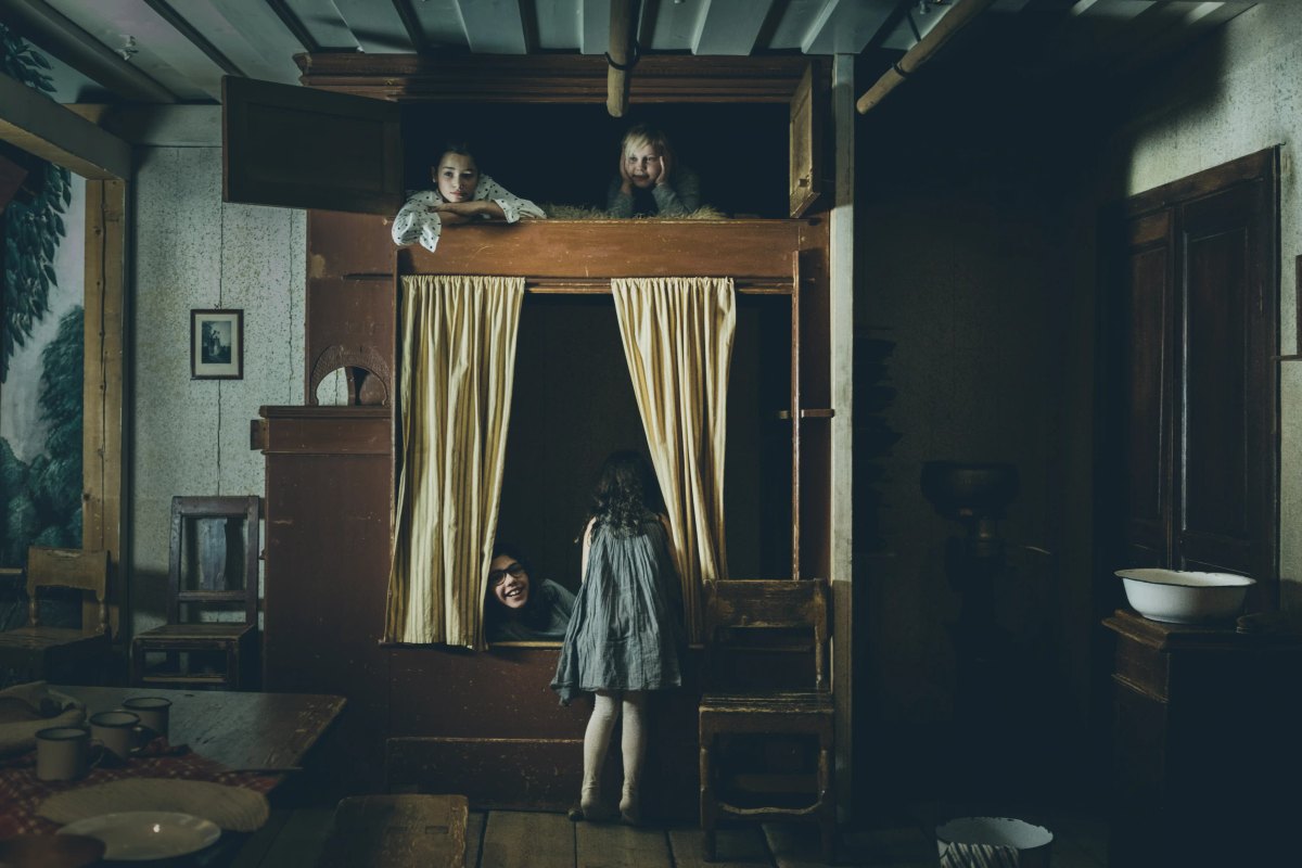 Children playing in the 1890s farmhouse kitchen of the Children's Playhouse at Nordiska museet