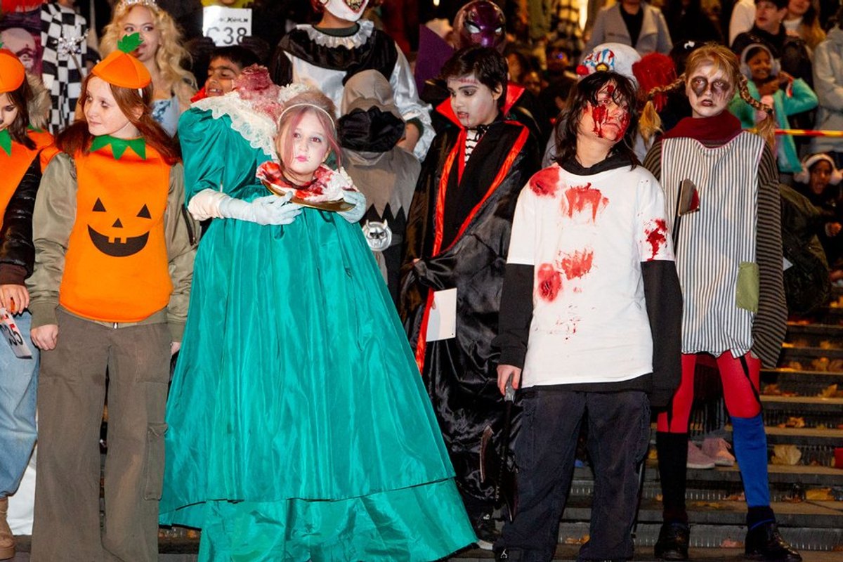 Children in Halloween costumes – a pumpkin, a princess, a zombie – on the steps at Sergels torg during Shockholm
