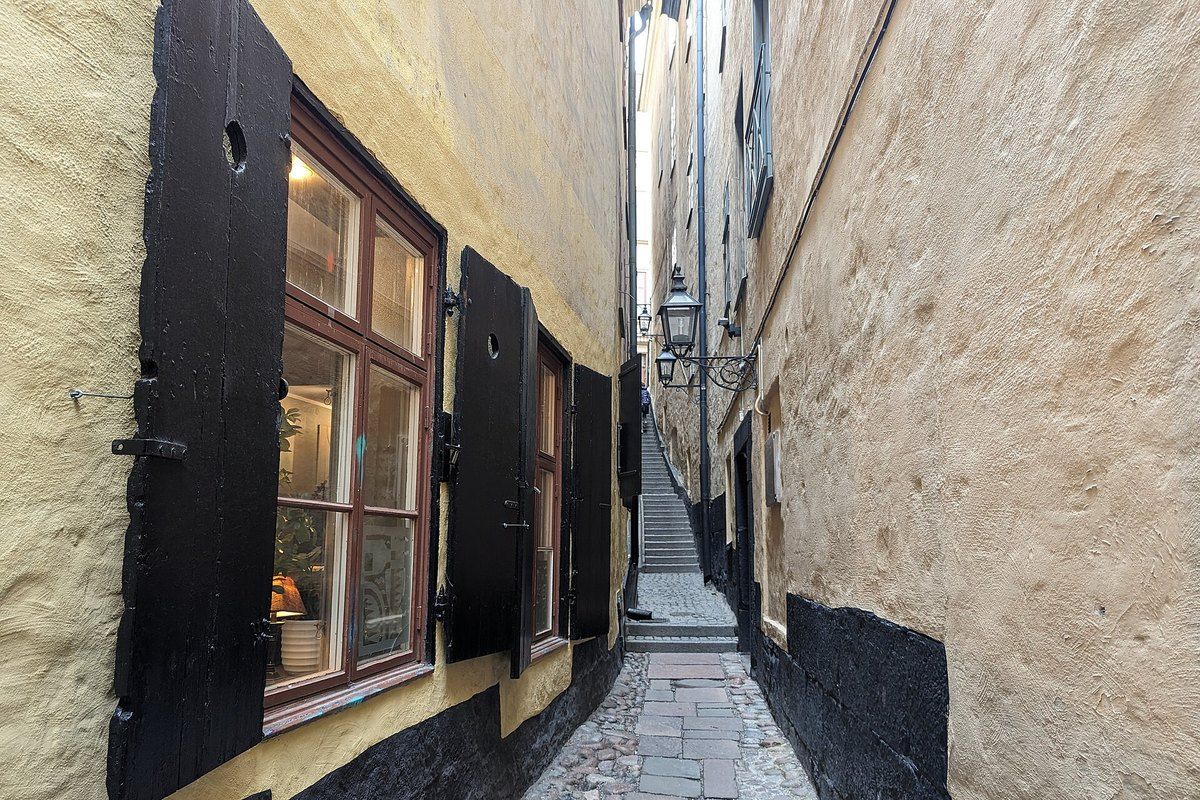 The narrow stepped alley of Mårten Trotzigs gränd in Gamla stan, between ochre walls and black shutters