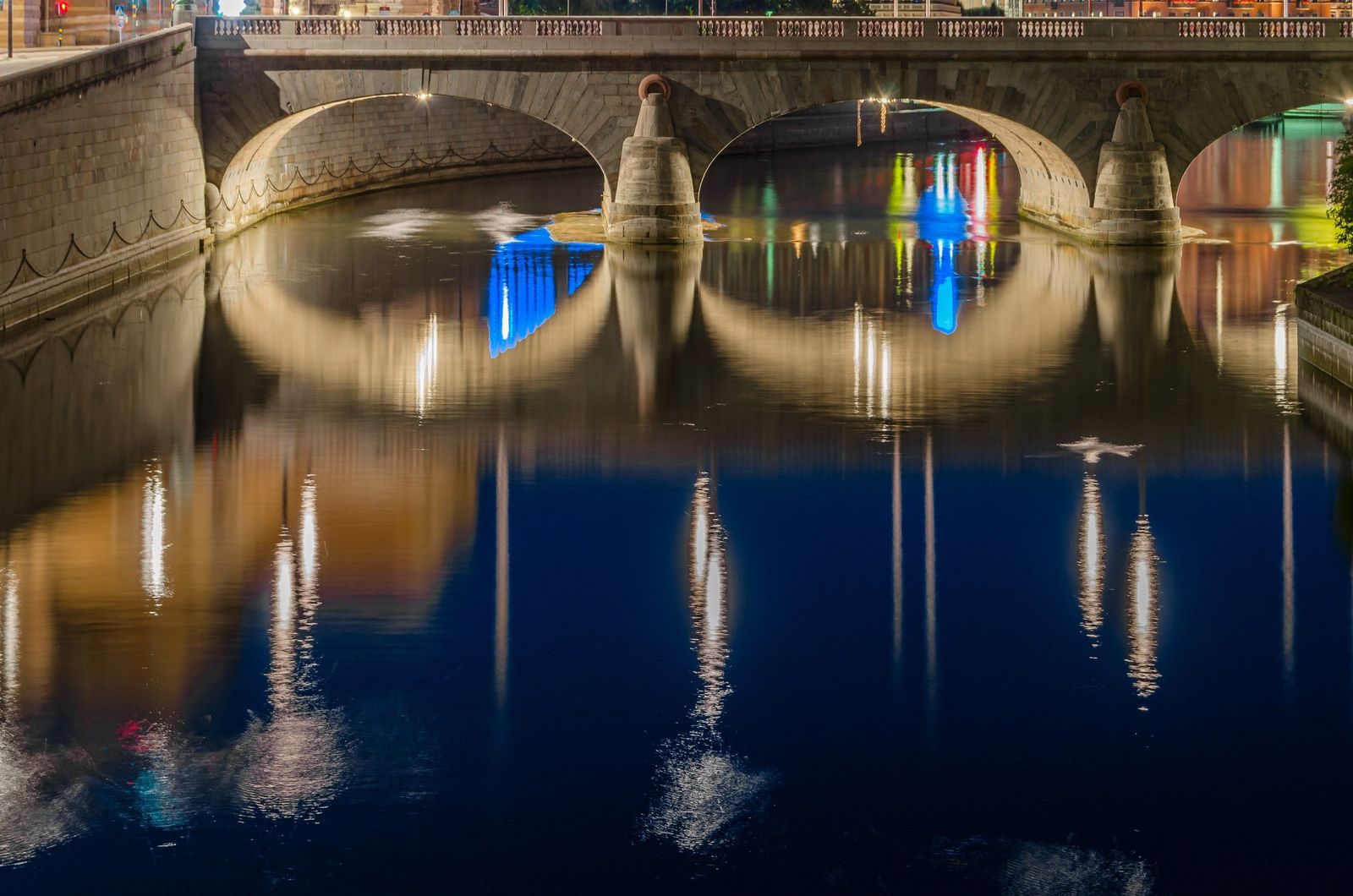 The Stockholm waterfront and its bridge arches lit at dusk