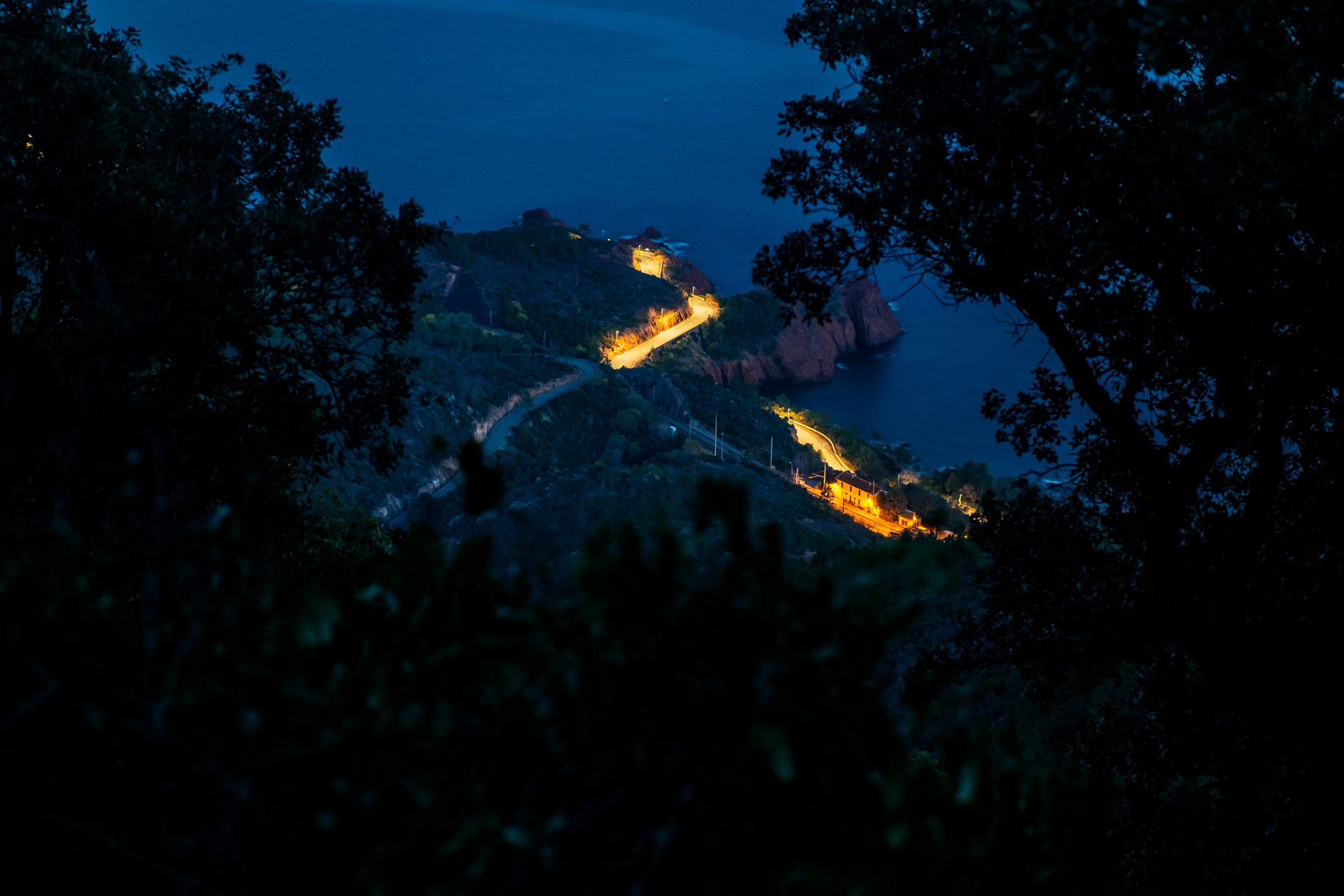 The coast road lit up at blue hour along the Esterel cliffs