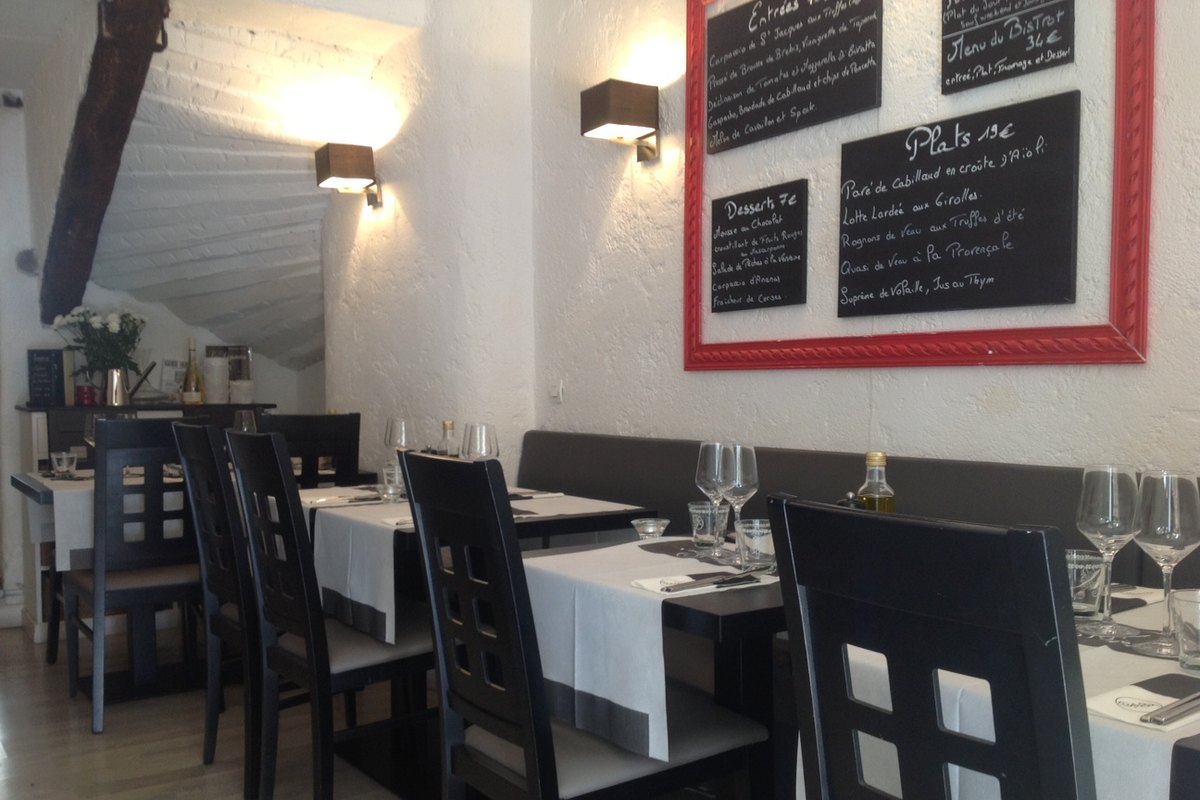 Black chairs, white tablecloths and chalkboard menus in the dining room of Le Bistrot du Sommelier