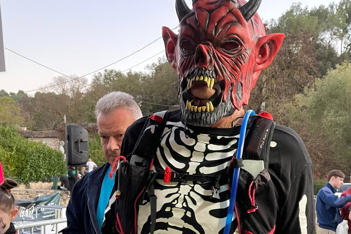A runner in a devil mask and skeleton top at the start of the Épouvant'Trail Halloween race in Valbonne
