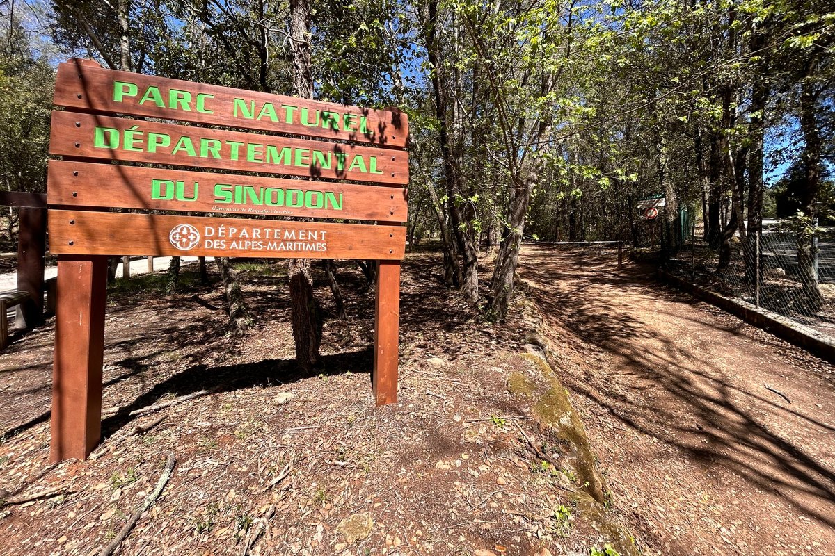 The wooden entrance sign of the Parc naturel départemental du Sinodon on a woodland track