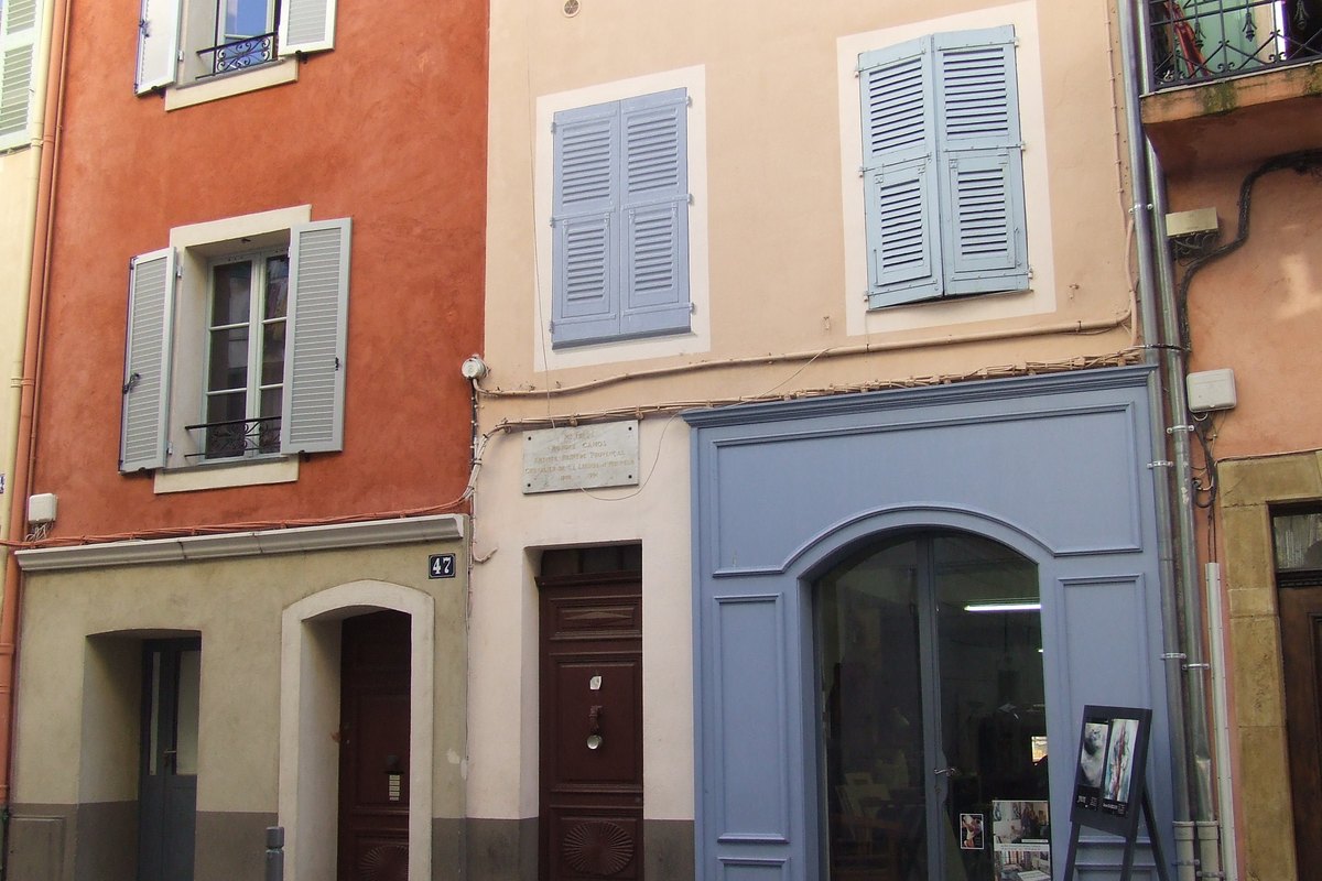 Ochre, red and blue shuttered façades and shop doors in the centre of Vallauris