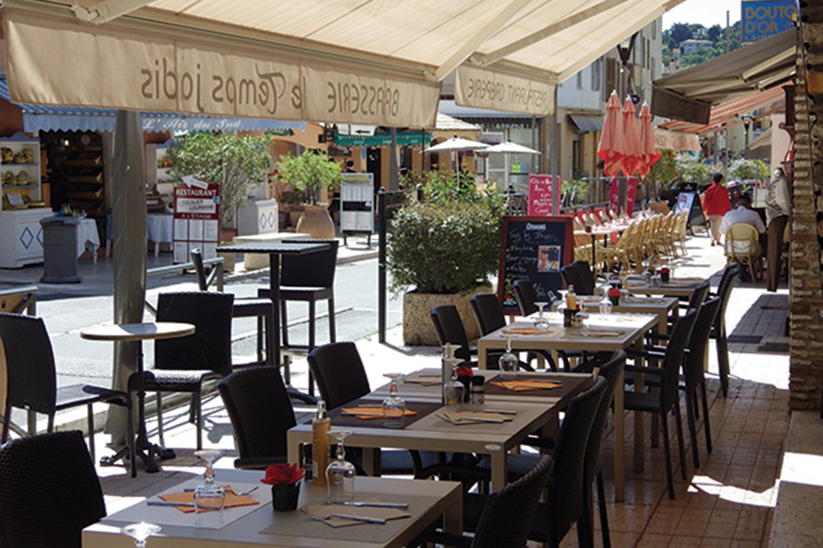 The awning-shaded pavement terrace of Le Temps Jadis on avenue Georges Clemenceau, Vallauris