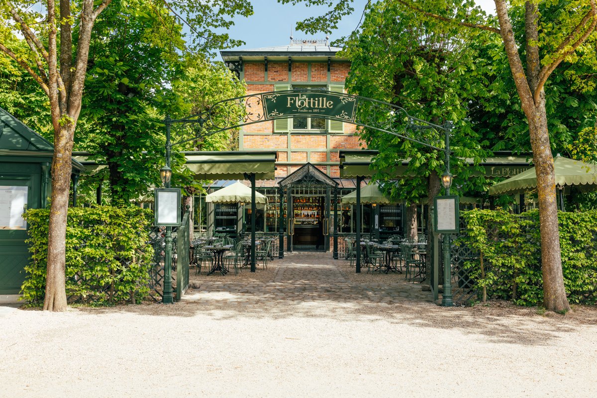 The green-trellised entrance and terrace of La Flottille restaurant beside the Grand Canal in the Park of Versailles