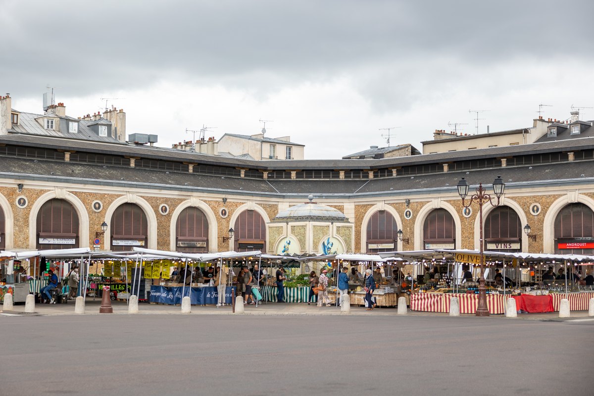 Market stalls in front of the arcaded halls of the Marché Notre-Dame in Versailles