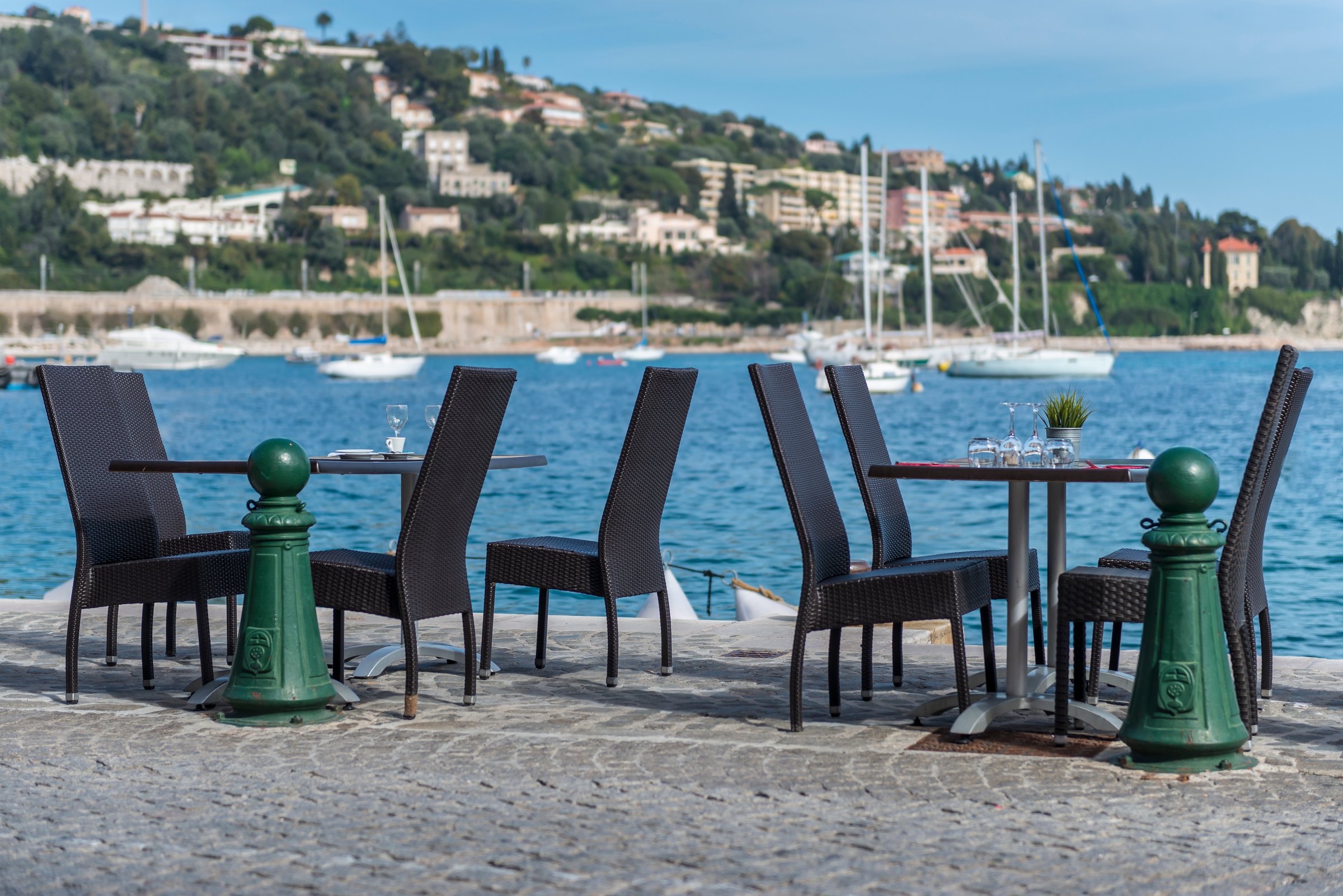 Restaurant tables at the edge of the harbour in Villefranche-sur-Mer
