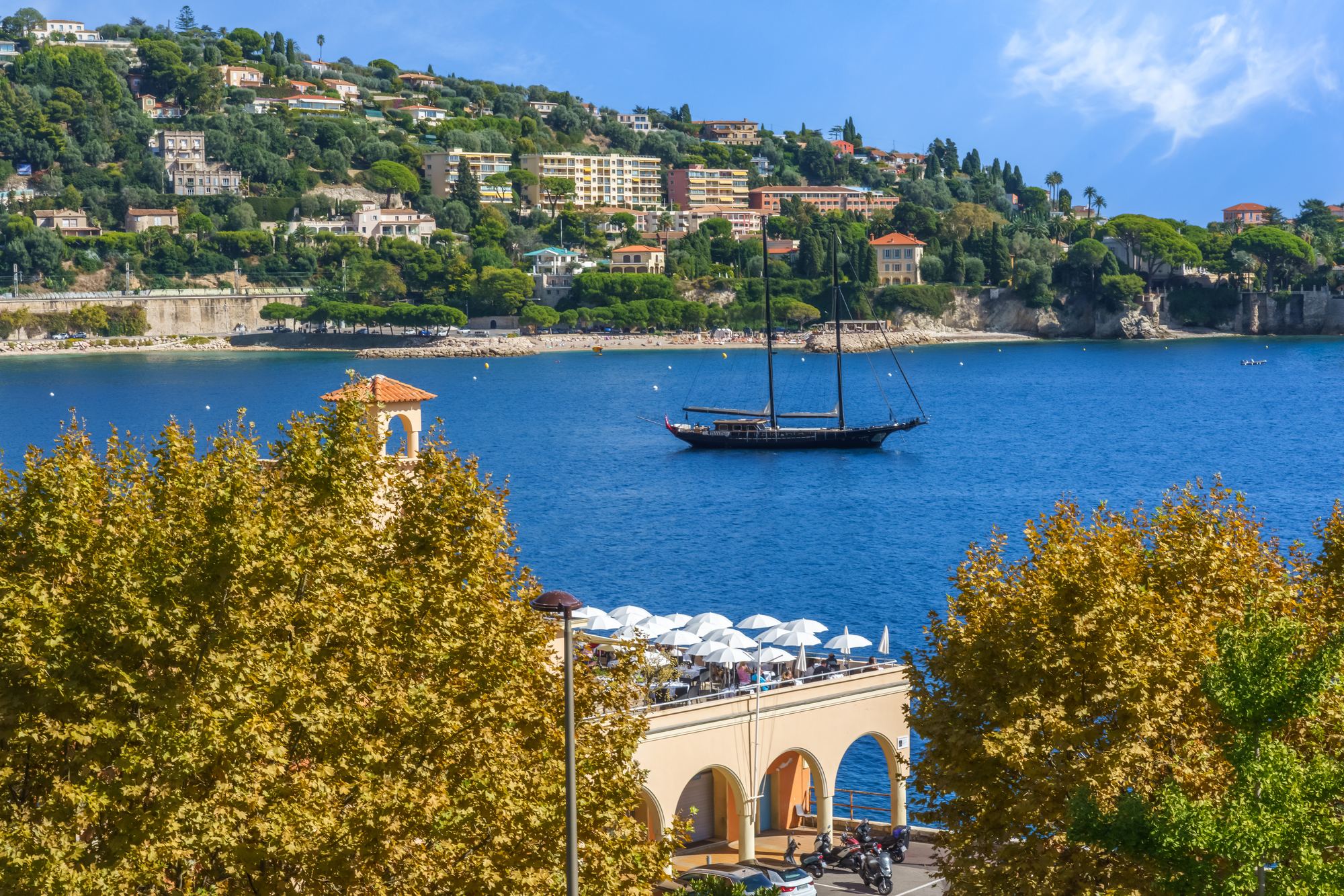 A sailboat in the calm bay of Villefranche-sur-Mer