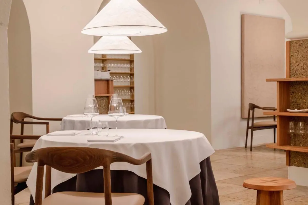 Elegant dining room with arched ceiling, set tables with white linens and wine glasses
