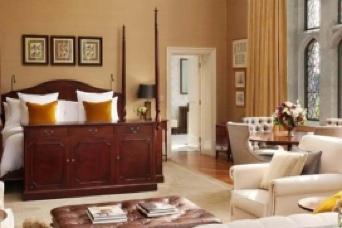 Spacious hotel suite with four-poster bed and seating area