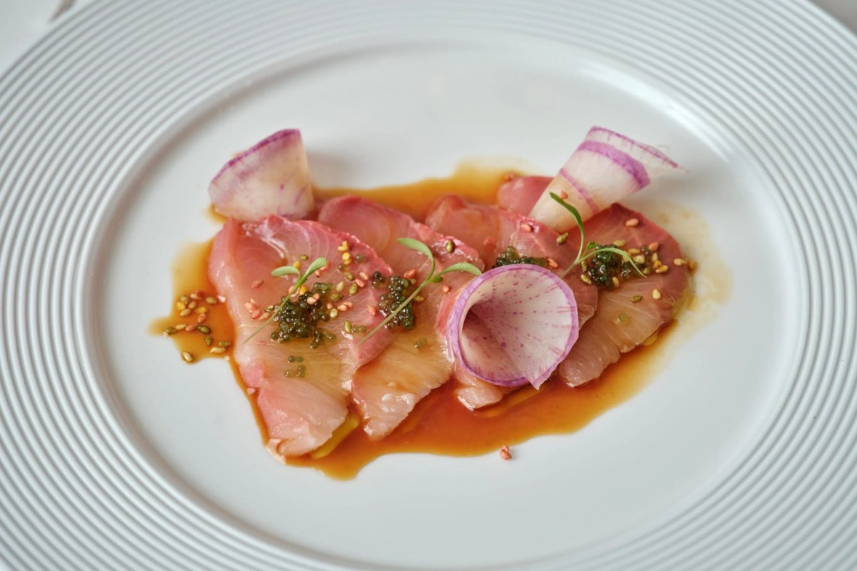 Plate of yellowtail sashimi with radish and herb garnish