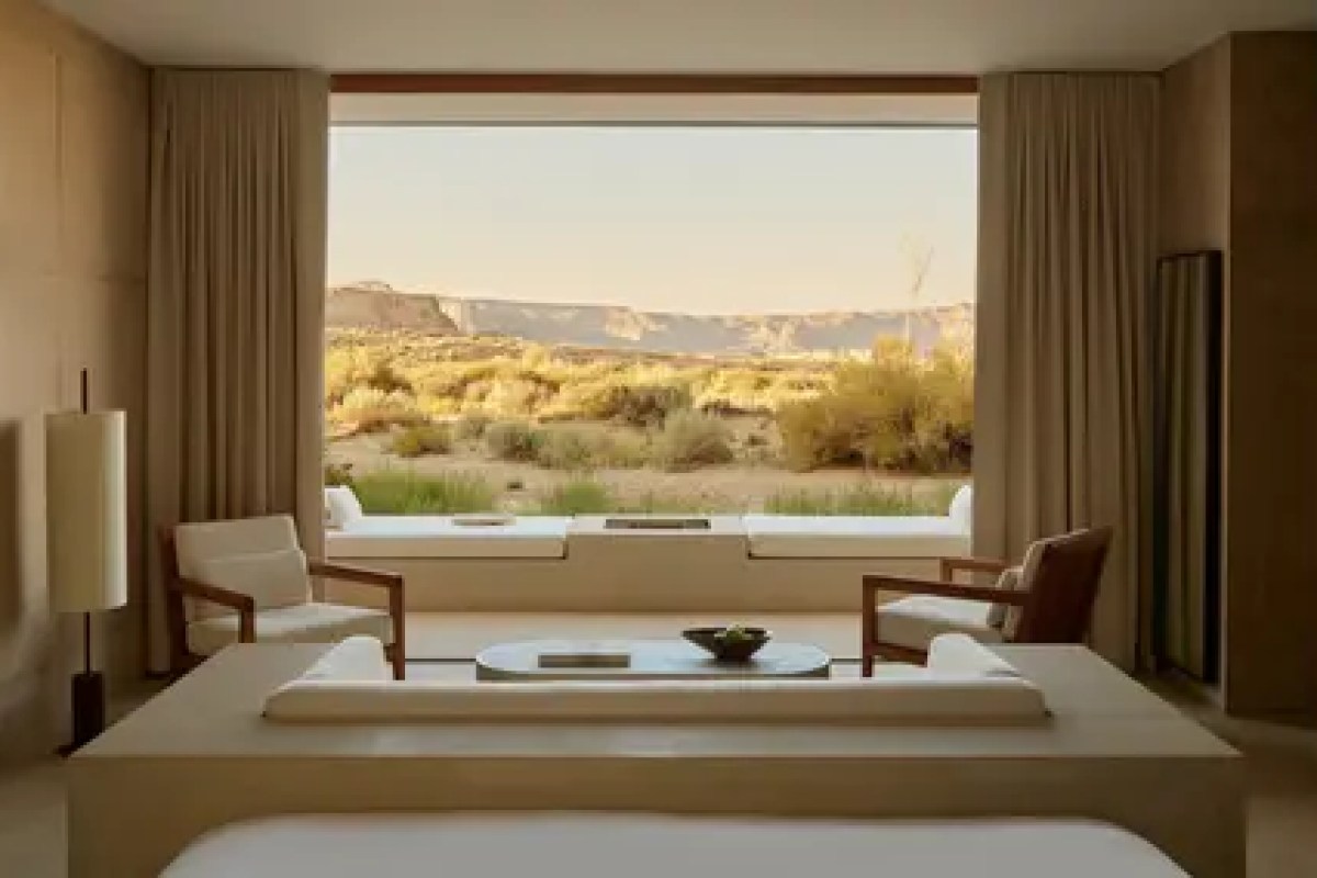 Guest suite interior with seating area and large window overlooking desert landscape.