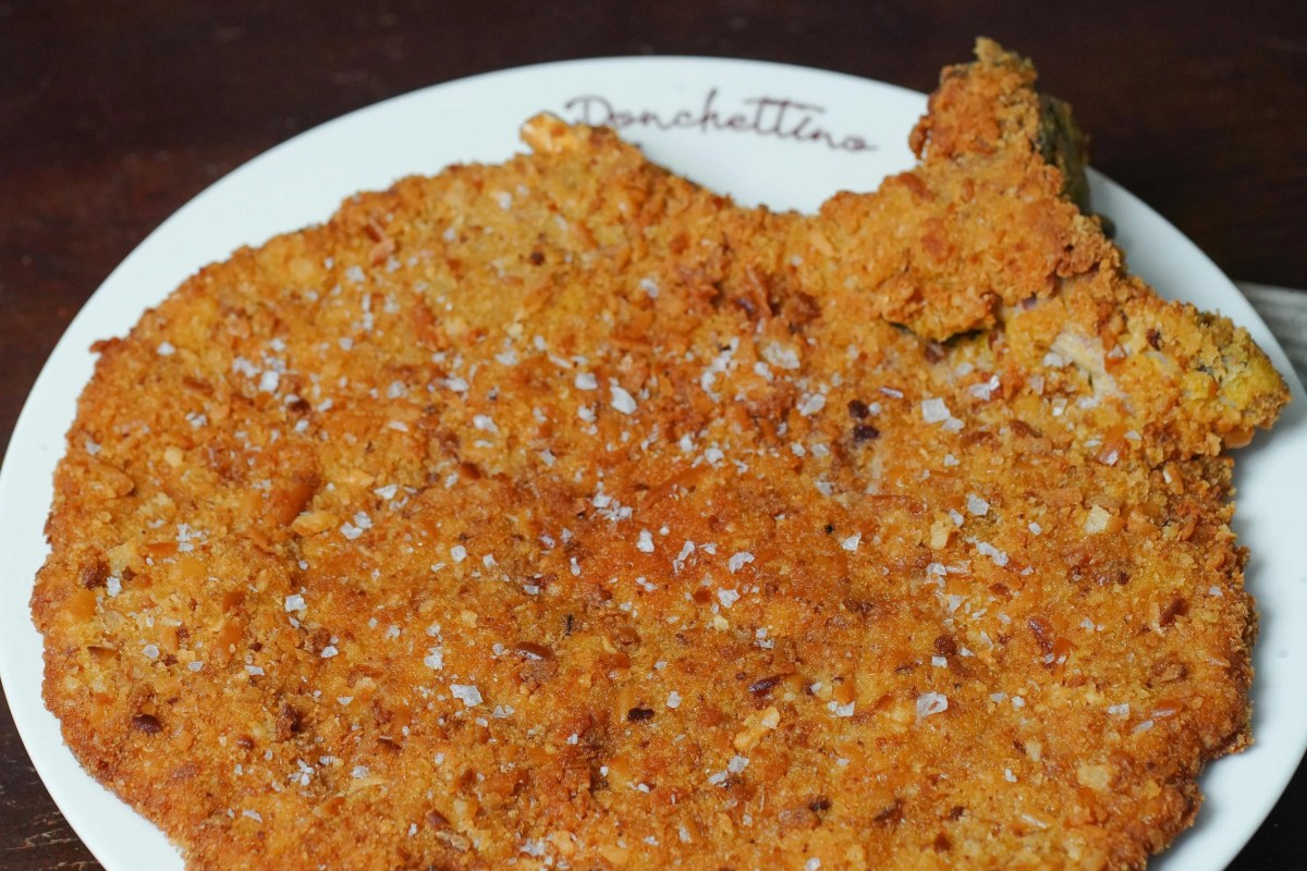 Breaded cutlet (cotoletta) on a plate marked Ronchettino, close-up