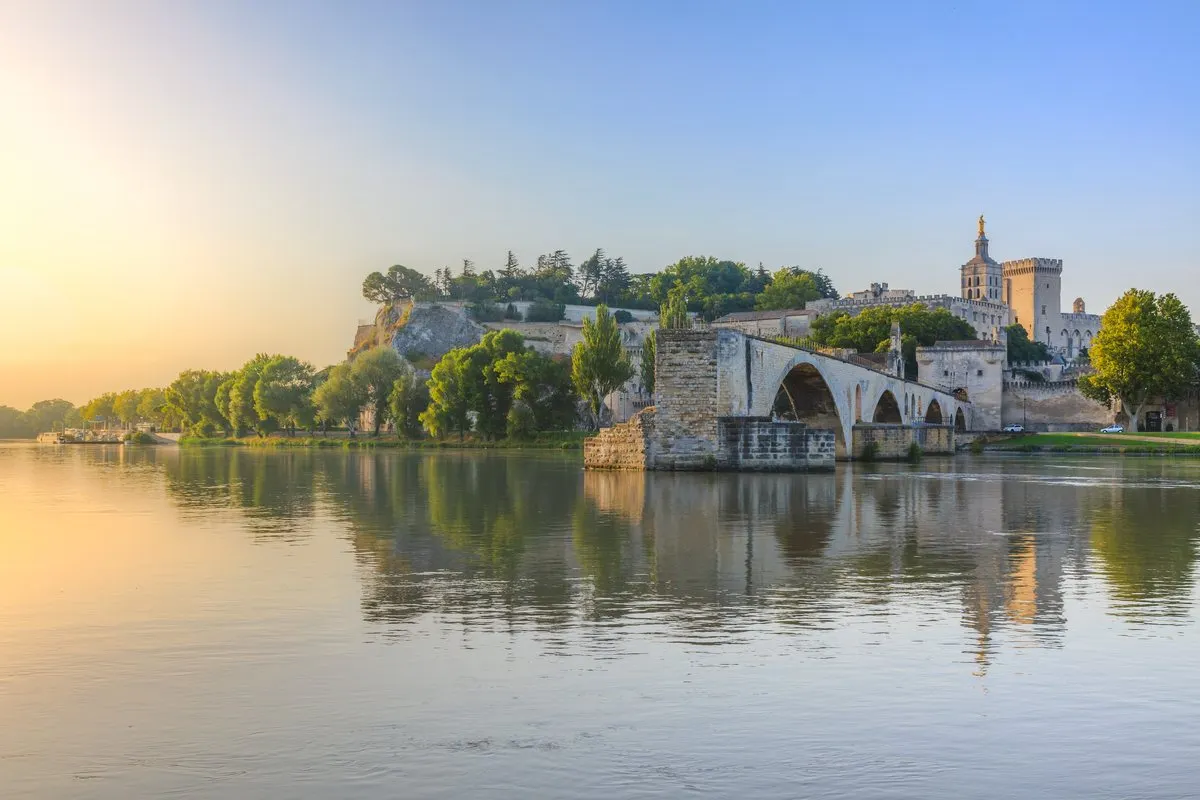 Pont Saint-Bénézet and the Palais des Papes in Avignon reflected in the Rhône at sunrise