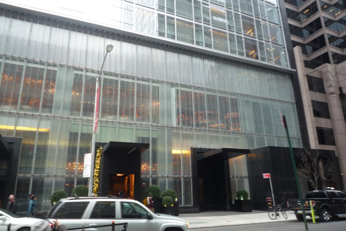 Baccarat Hotel exterior facade with fluted glass panels, dark entrance canopies, and street-level view
