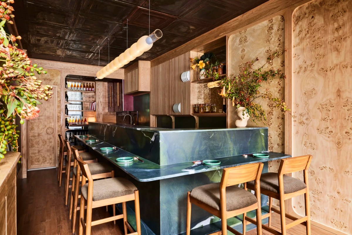 Interior of Bar Miller showing green marble bar counter, wooden stools, and decorative wood paneling