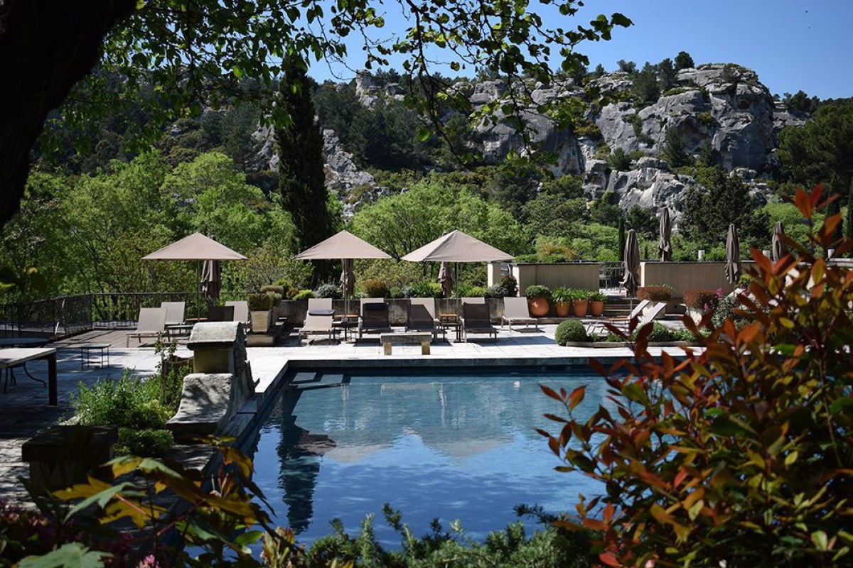 Hotel pool and sun loungers with the Les Baux limestone cliffs in the background