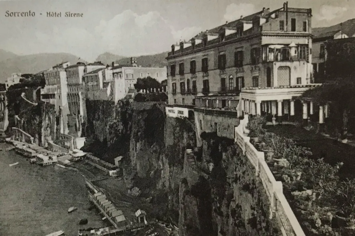 Black and white postcard view of Hotel Sirene building perched on a cliff above the sea in Sorrento.