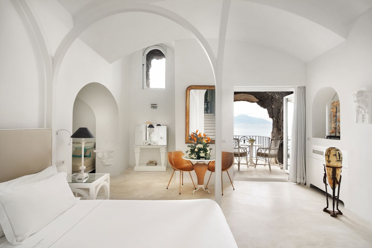 Spacious white vaulted suite with sea-view balcony and seating area