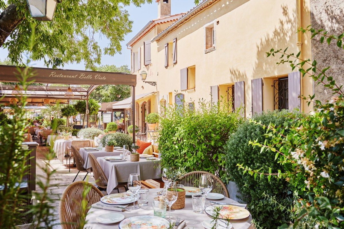 Terrace with set tables and ochre building facade at Restaurant Belle Visto