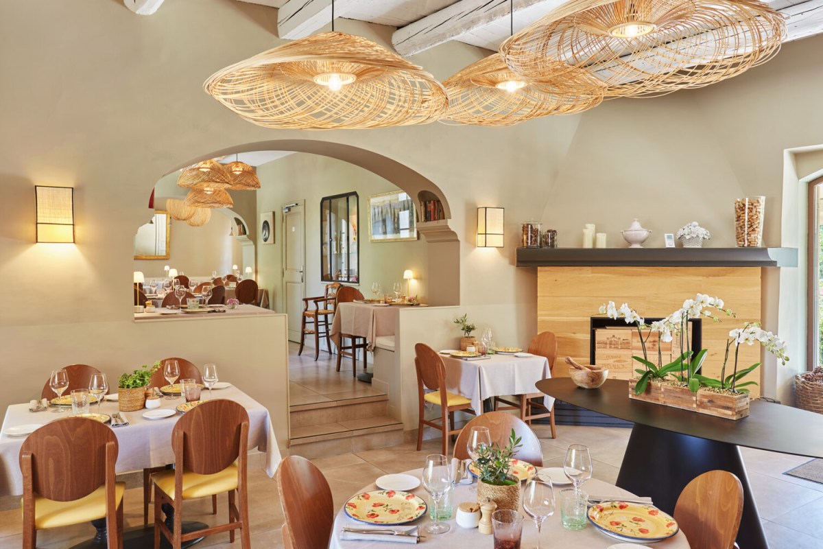 Cozy dining room interior with wicker lamps, fireplace and set tables