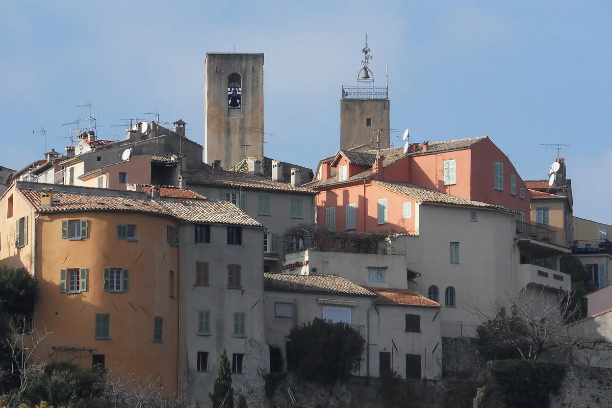 Ochre and pink houses of the old village of Biot, with its bell towers against a clear sky
