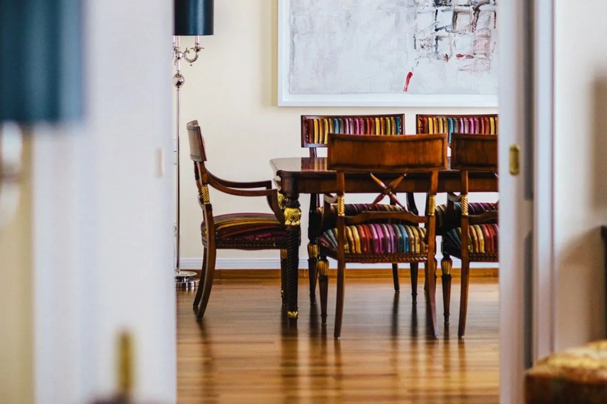 View through doorway into elegant dining area with striped upholstered chairs and dark wood table
