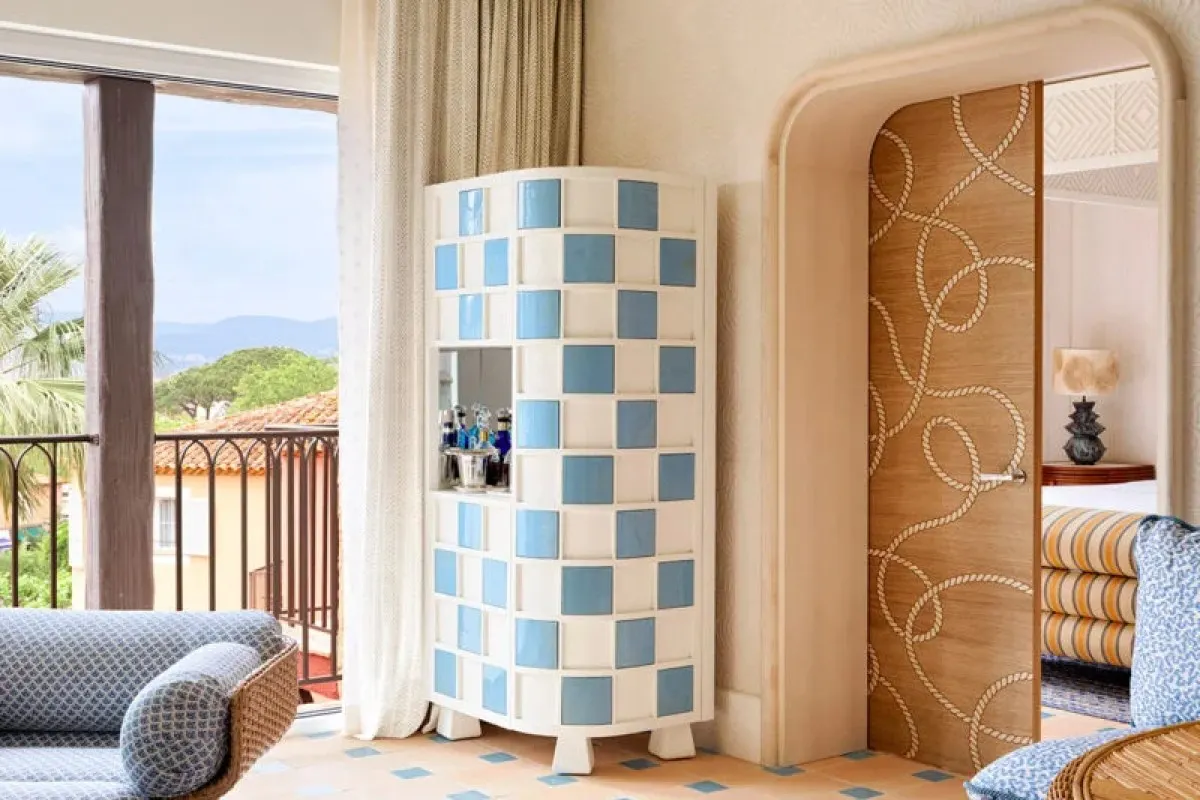 Room corner with blue-and-white tiled bar cabinet, balcony view and patterned door