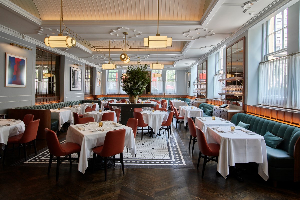Dining room with white tablecloths, teal banquettes, red chairs and brass chandeliers