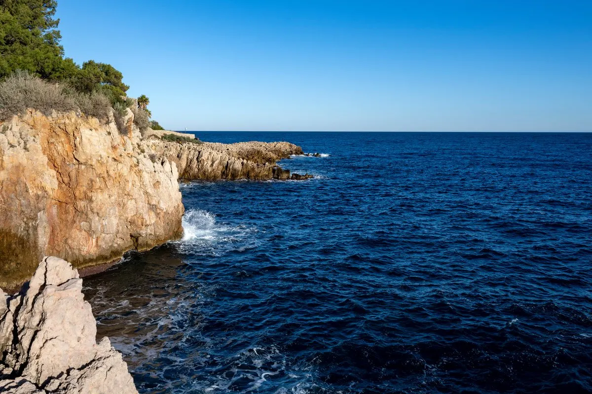 Limestone cliffs plunging into the deep blue Mediterranean at Cap d'Antibes on a clear winter's day