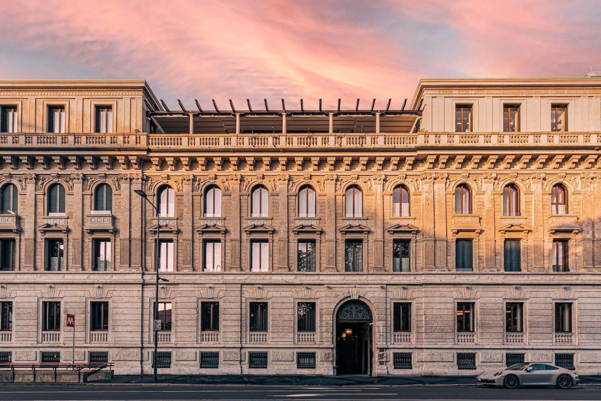 Classical facade of Casa Cipriani Milano at sunset with a sports car parked outside