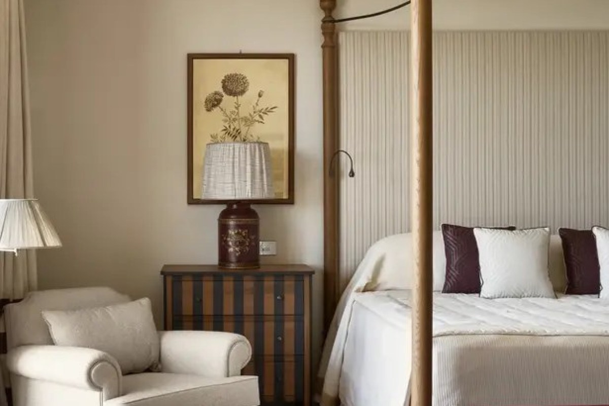 Guest room with four-poster bed, armchair, and vintage decor
