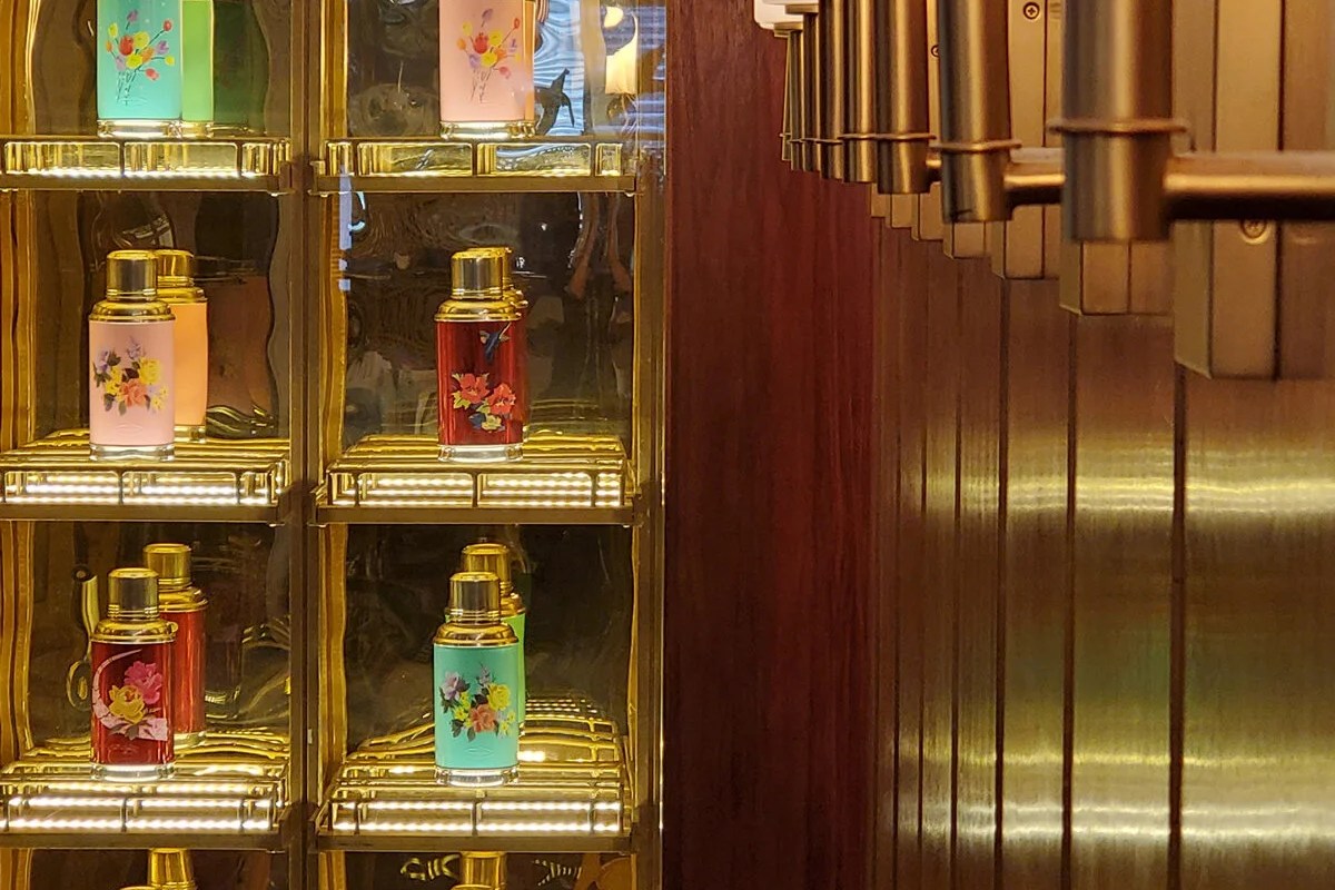Decorative gold shelving with floral tins and brass bar details inside Cha Kee