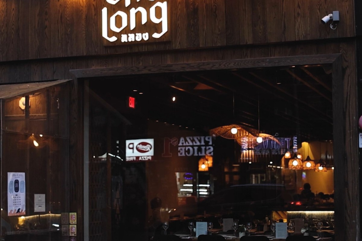 Restaurant exterior storefront at dusk with illuminated 'Chalong' sign and interior dining room visible through window