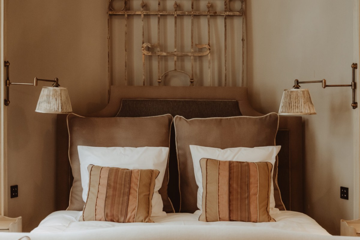 Close-up of hotel bed headboard with decorative wrought iron piece and striped pillows