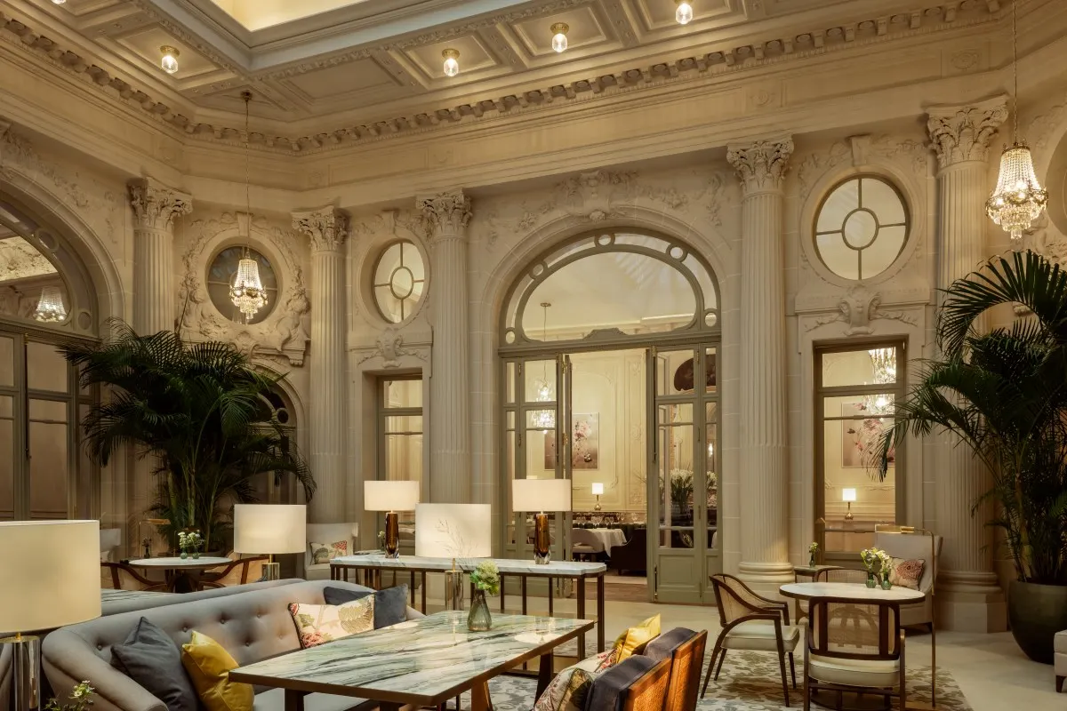 Elegant hotel lounge with classical columns, palms, chandeliers and lounge seating