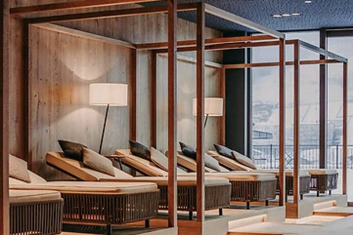 Modern wood-framed lounge chairs in spa relaxation area with mountain view windows