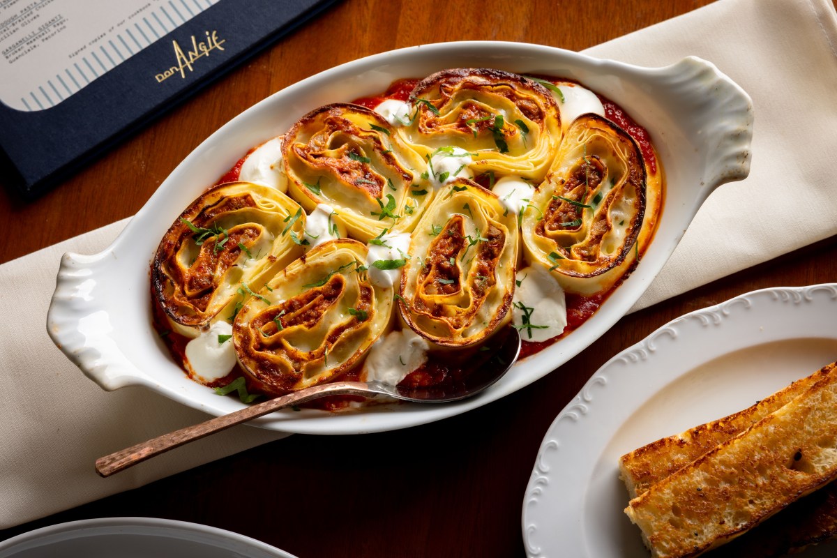 Baked pasta roll-ups in red sauce with mozzarella, Don Angie menu visible on table