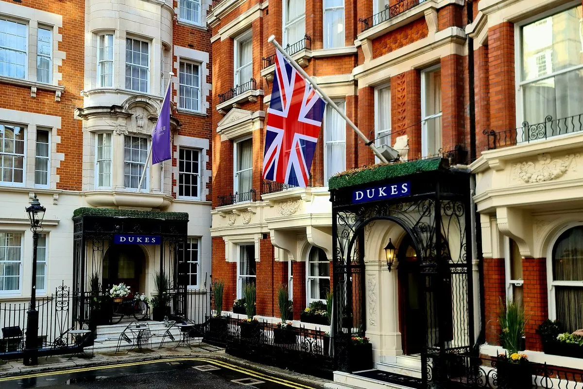 The red-brick Edwardian frontage of DUKES London in St James's Place, with its wrought-iron canopy and Union Flag