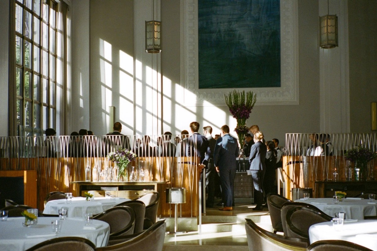 Elegant dining room interior with tall windows, sunlight, and art deco décor at Eleven Madison Park