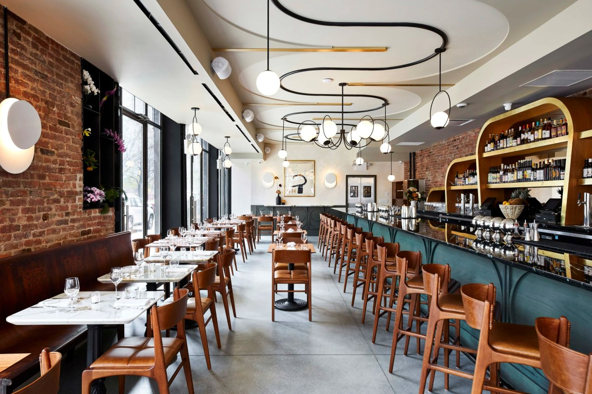 Interior dining room with exposed brick, brass bar, pendant lights and leather chairs at Ernesto's