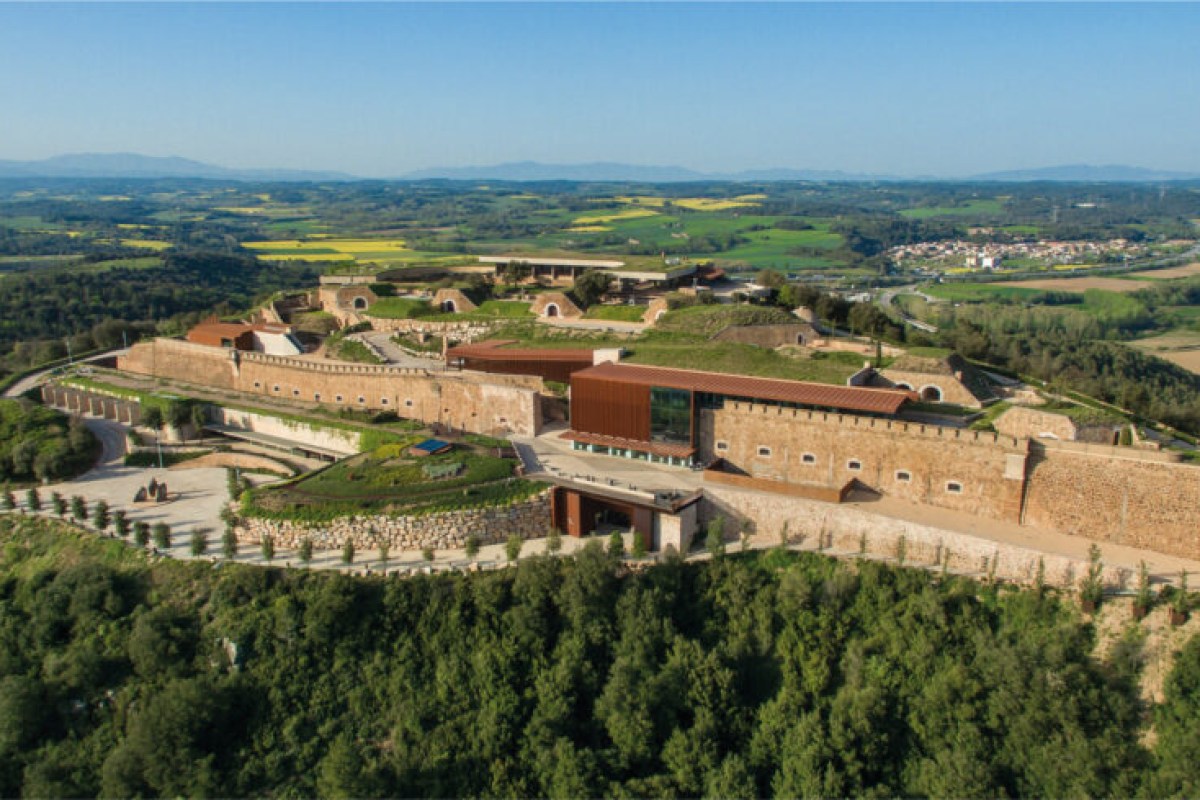 Aerial view of Esperit Roca hotel, a converted hilltop fortress surrounded by green countryside near Girona