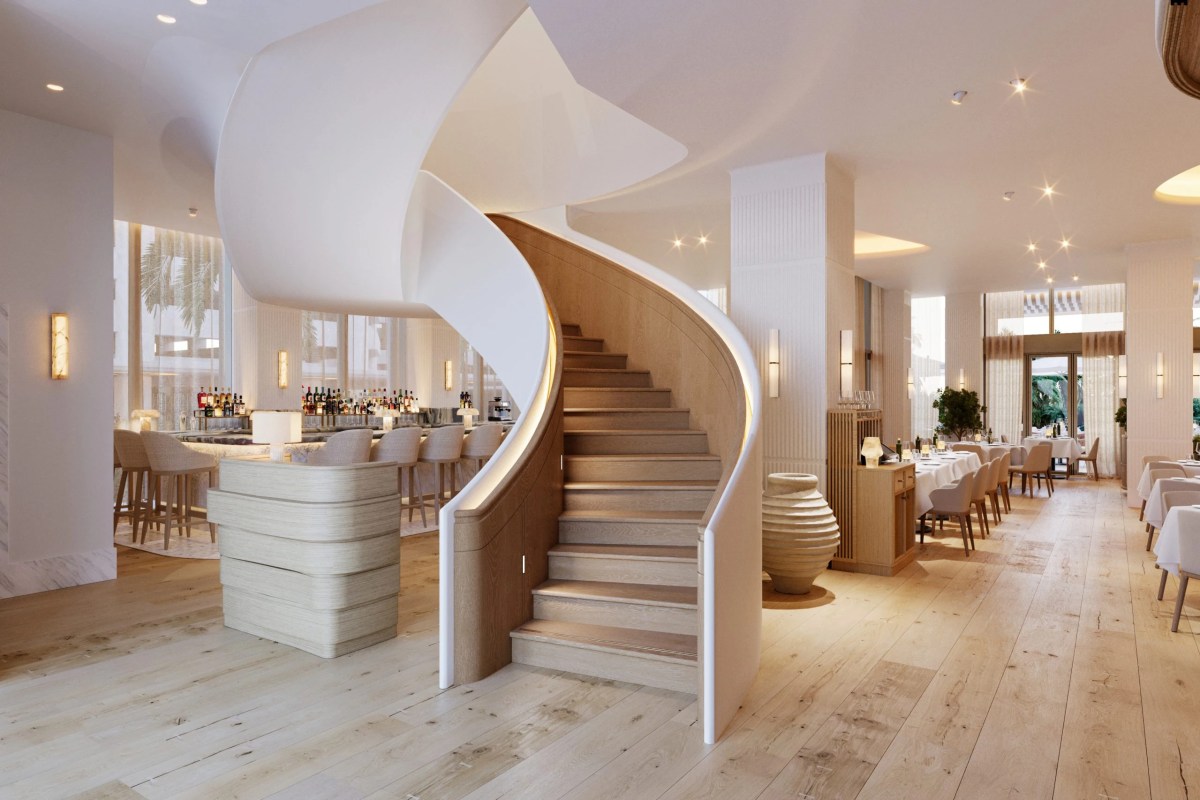 Elegant restaurant interior with a curved wooden staircase, bar area, and white-clothed dining tables