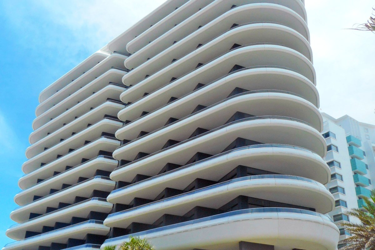 Close-up of Faena Hotel Miami Beach's curved white balconies against a blue sky
