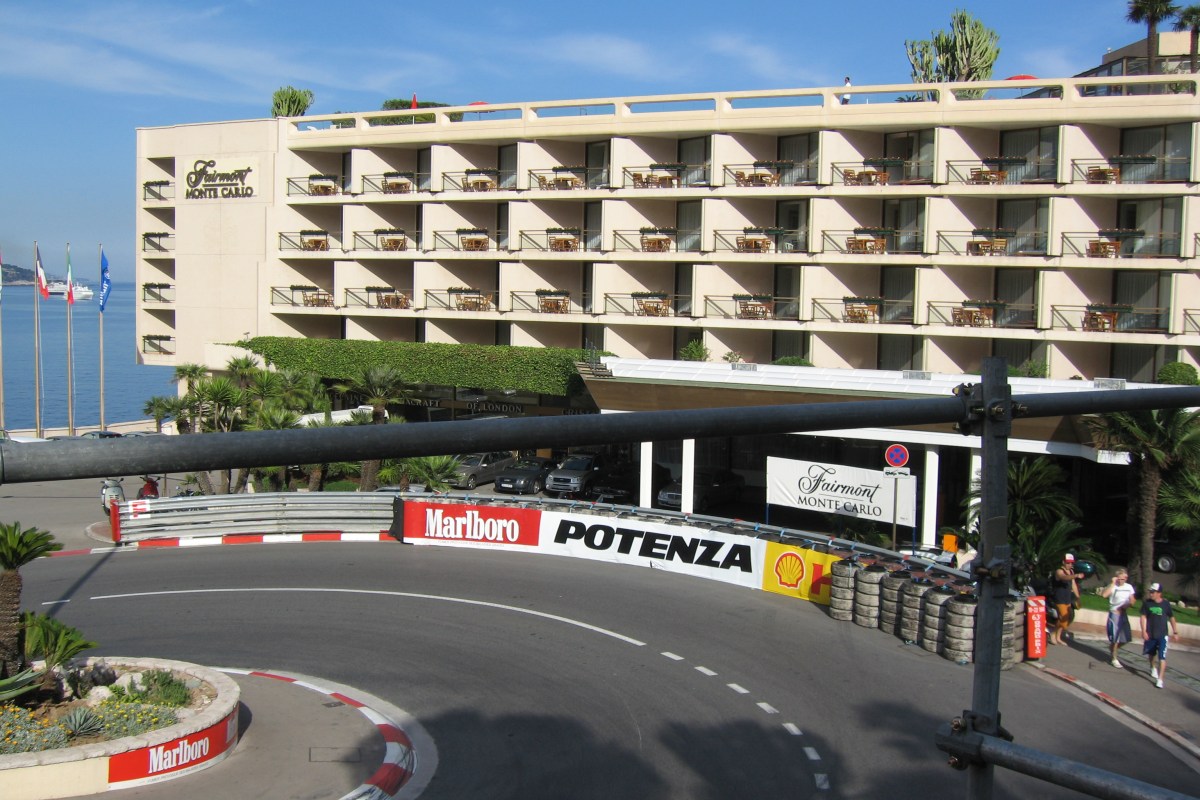 Fairmont Monte Carlo facade with sign, balconies and race track barriers in foreground