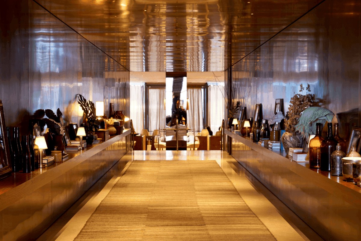 Elegant mirrored hallway leading to dining area with lamps and decor