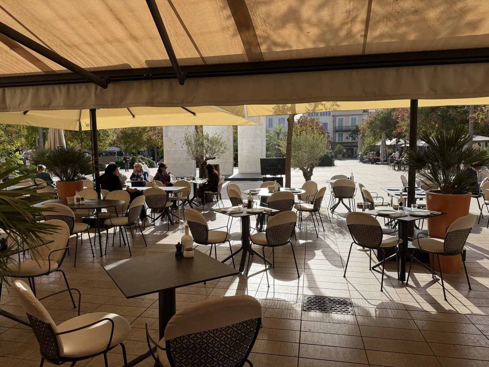 Looking out from under Ferni's awnings across its terrace to the Place des Martyrs de la Résistance in Antibes